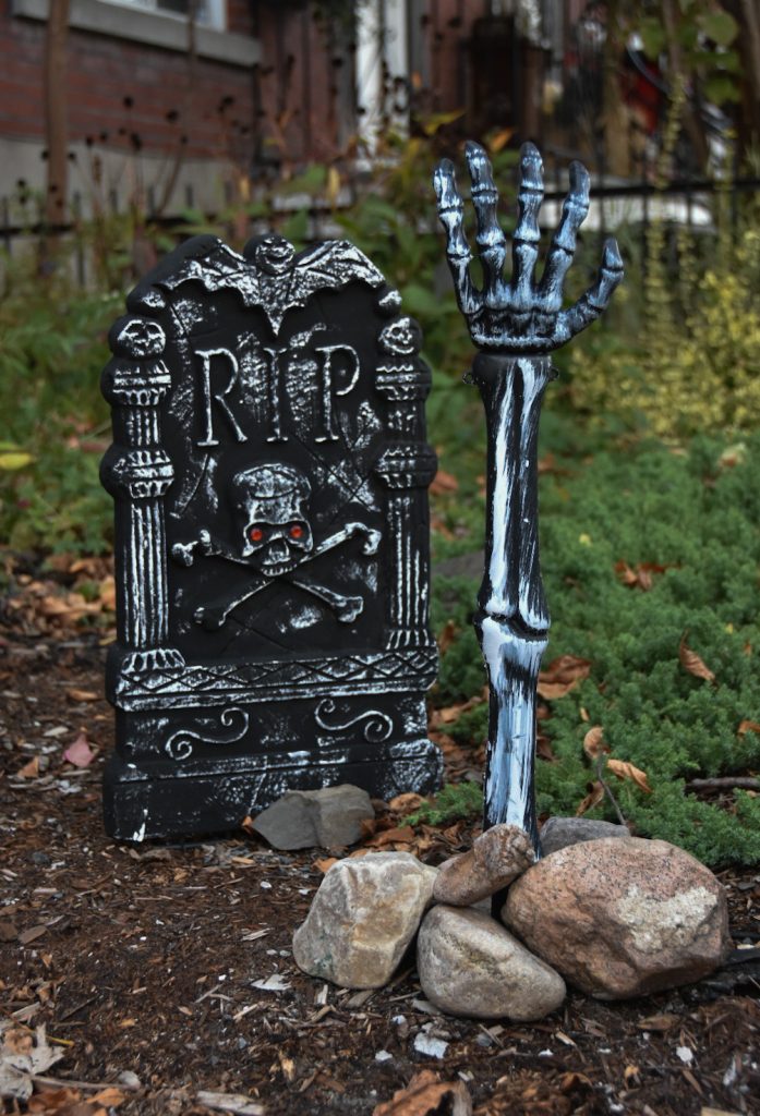 Halloween outdoor decor tombstone skeleton arm reaching out of the ground